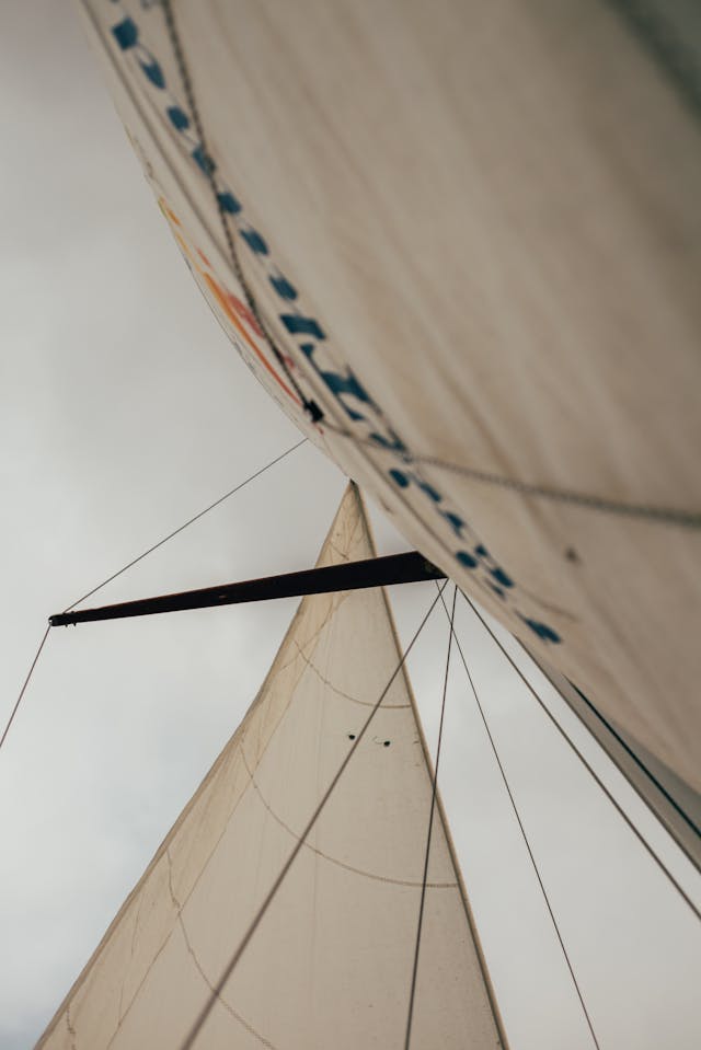 Close-up of the powerful head of a sail perfectly capturing the wind, symbolizing the ability to harness influence and propel oneself forward, a core skill taught in Playbook 2: Influence.